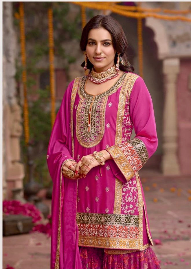 Indian woman wearing a vibrant pink floral printed sharara suit with mirror work and embroidery, styled for festive occasions like Diwali, Rakhi, Teej, and weddings – Meraki Vastram ethnic wear UAE.