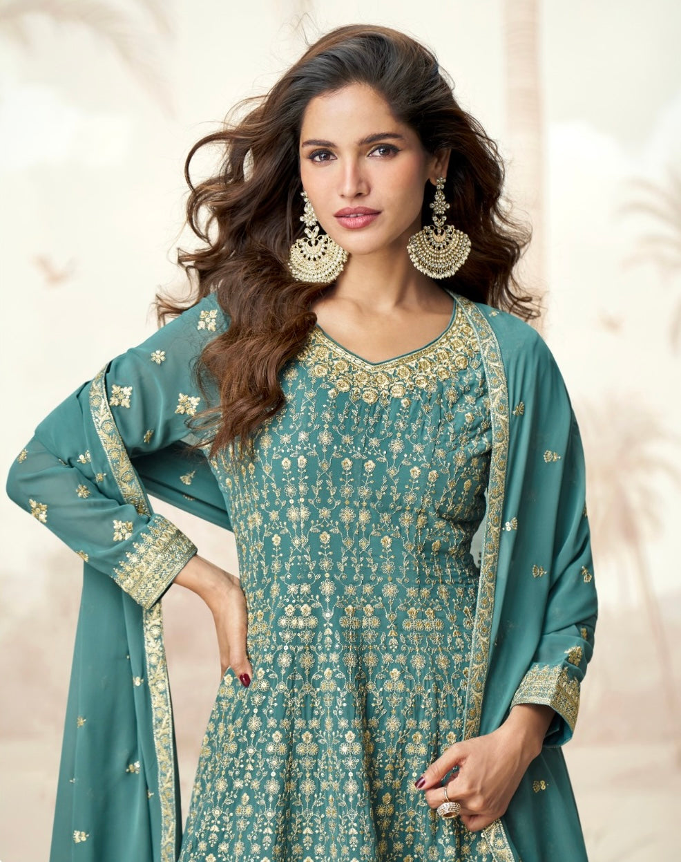 Woman wearing a teal blue Anarkali sharara suit with gold zari embroidery, styled for festive occasions like Diwali, Rakhi, Ganpati, Teej & weddings – ethnic wear by Meraki Vastram UAE.