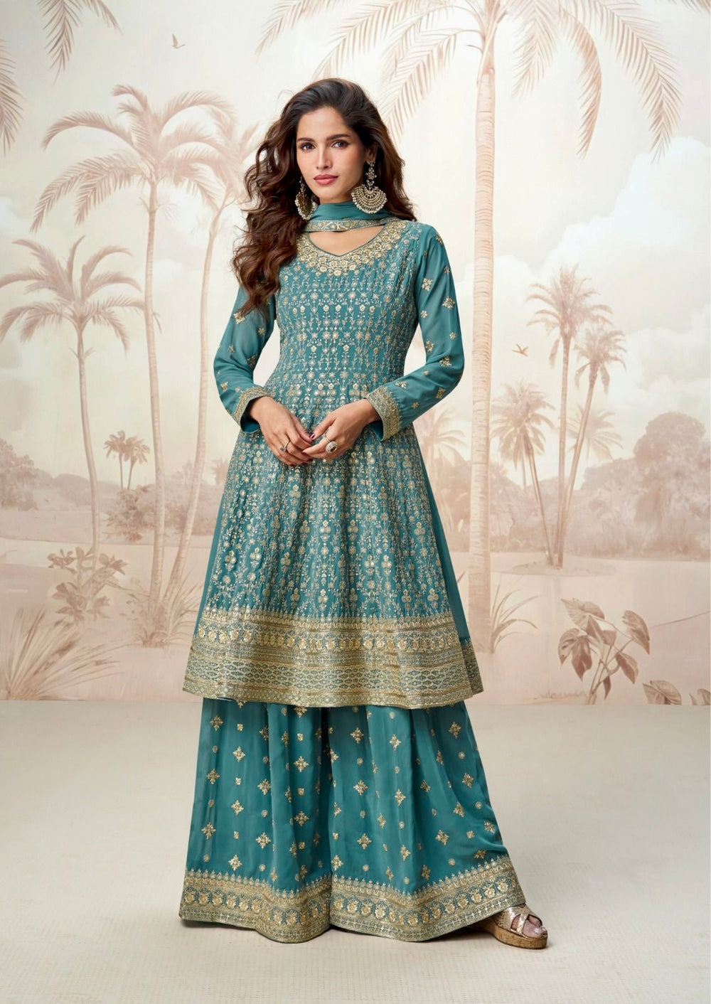 Woman wearing a teal green Anarkali sharara suit with gold zari embroidery, styled for festive occasions like Diwali, Rakhi, Ganpati, Teej & weddings – ethnic wear by Meraki Vastram UAE.