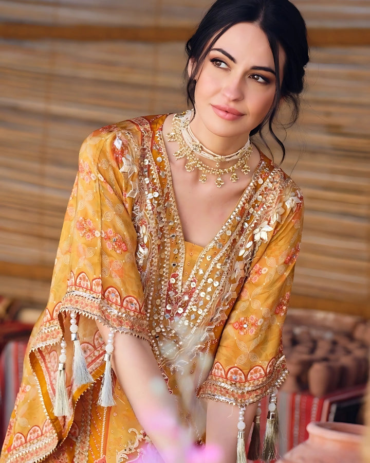 Woman wearing a mustard yellow embroidered kaftan kurta with sharara pants and tassel details – festive outfit for Mehendi, Diwali, Teej and Haldi in UAE by Meraki Vastram.