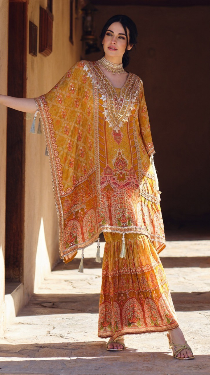 Woman wearing a mustard yellow embroidered kaftan kurta with sharara pants and tassel details – festive outfit for Mehendi, Diwali, Teej and Haldi in UAE by Meraki Vastram.