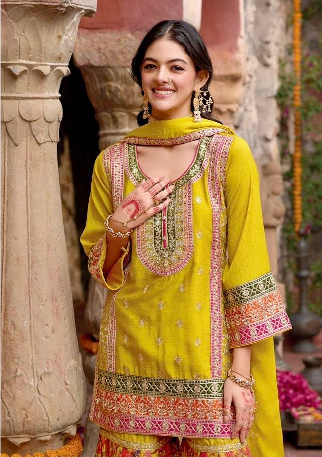 Indian woman wearing a vibrant yellow floral printed sharara suit with mirror work and embroidery, styled for festive occasions like Diwali, Rakhi, Teej, and weddings – Meraki Vastram ethnic wear UAE.
