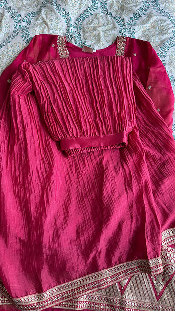 Woman wearing a coral and fuchsia sharara suit with embroidered kurta and pink printed dupatta – ideal for Diwali, Rakhi, Karwachauth, and wedding functions in UAE by Meraki Vastram.