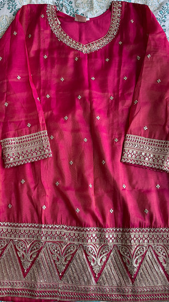 Woman wearing a coral and fuchsia sharara suit with embroidered kurta and pink printed dupatta – ideal for Diwali, Rakhi, Karwachauth, and wedding functions in UAE by Meraki Vastram.