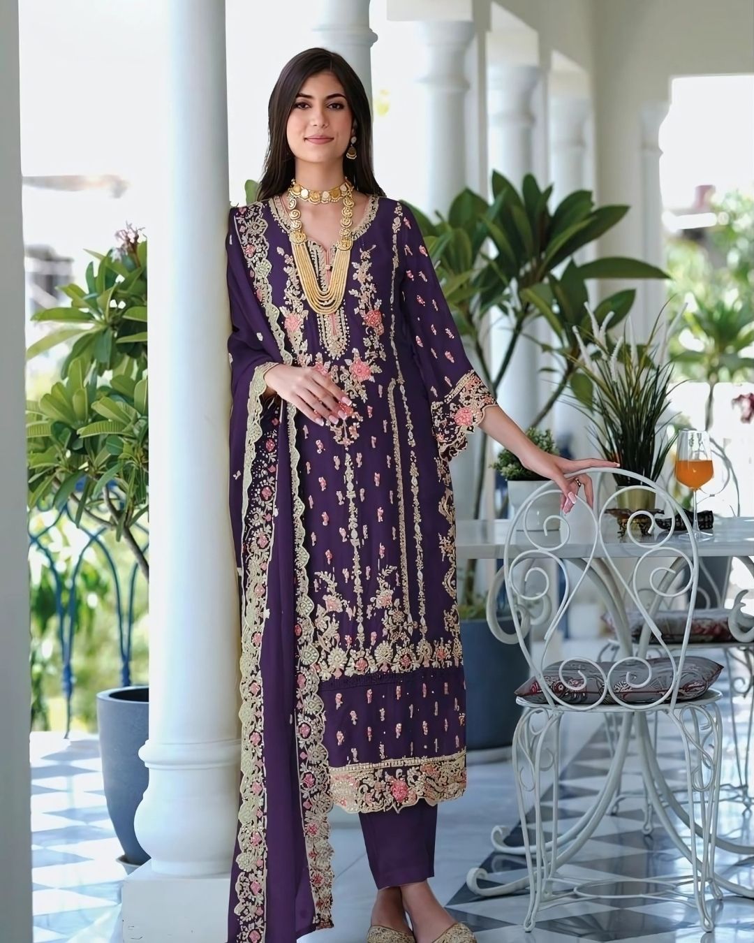 Woman wearing a deep plum embroidered straight-cut suit with floral detailing and matching dupatta, ideal for Diwali, weddings, and festive wear – Meraki Vastram UAE ethnic collection.
