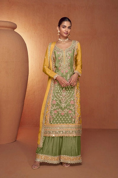 Woman wearing an olive green embroidered palazzo pakistani suit with mustard yellow dupatta – perfect festive outfit for Rakhi, Diwali, Teej, and haldi functions in UAE by Meraki Vastram.
