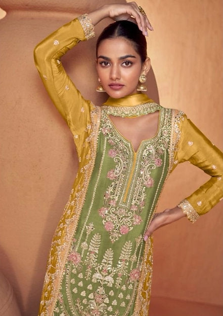 Woman wearing an olive green embroidered palazzo pakistani suit with mustard yellow dupatta – perfect festive outfit for Rakhi, Diwali, Teej, and haldi functions in UAE by Meraki Vastram.