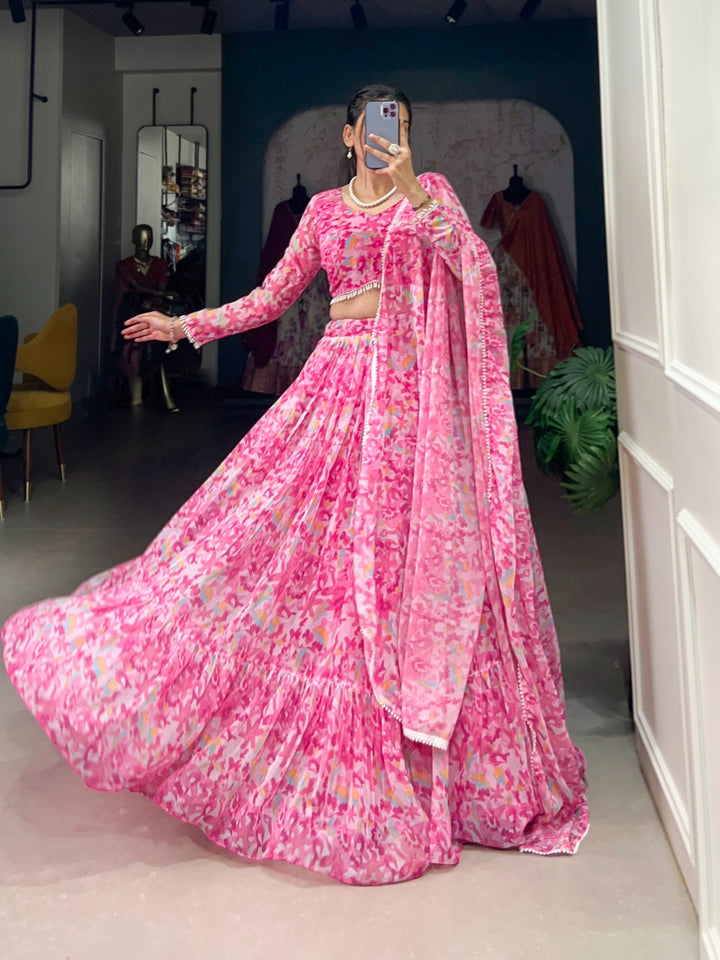 Woman wearing a flowy pink floral printed georgette lehenga with matching blouse and dupatta, perfect for Rakhi, Teej, Ganpati & wedding festivities – Meraki Vastram ethnic wear in UAE.